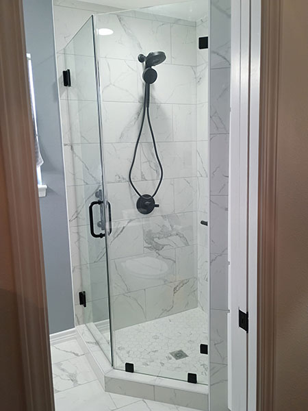 Two piece shower door and panel with matte black handle and hardware